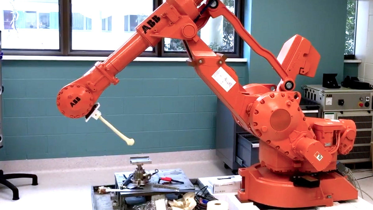 George the robot manipulating a humerus model at QUT